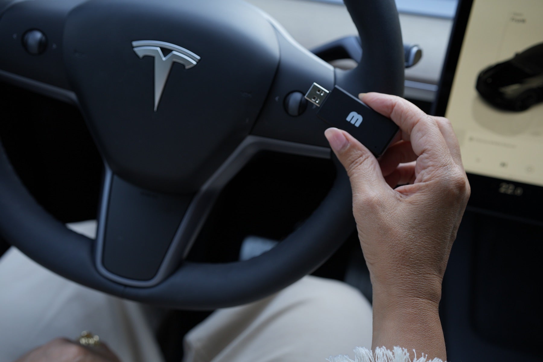 Holding the MATT3R K3Y in front of a Tesla steering wheel